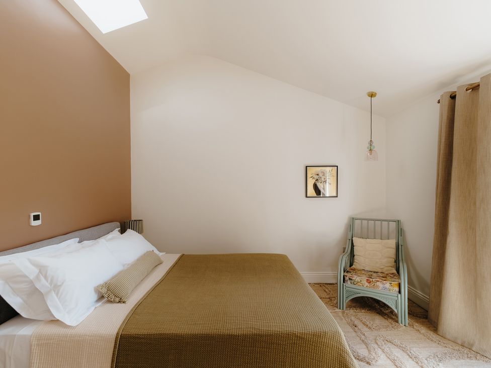 A bedroom with a bed and chair at Baldslow Barn Battle near Hastings