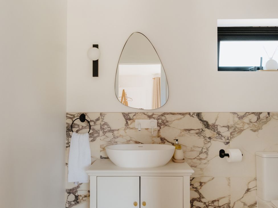A bathroom with a sink and a mirror at Baldslow Barn in Battle near Hastings
