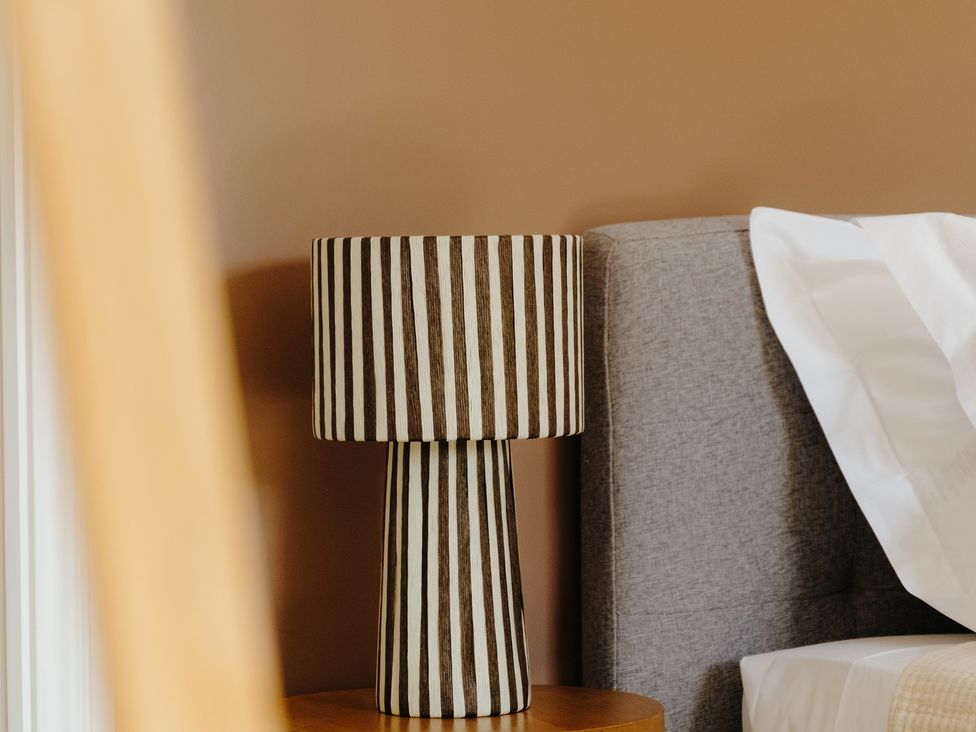 A lamp and bedside table in a bedroom at Baldslow Barn in Battle near Hastings