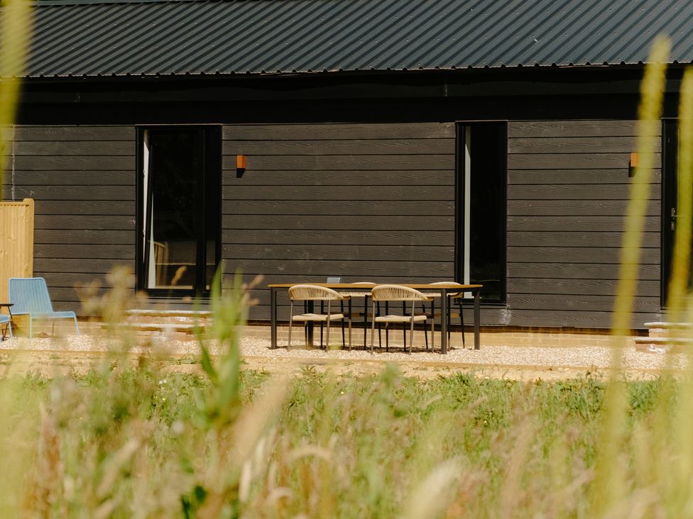 A table and chairs in front of a building at Baldslow Barn in Battle near Hastings