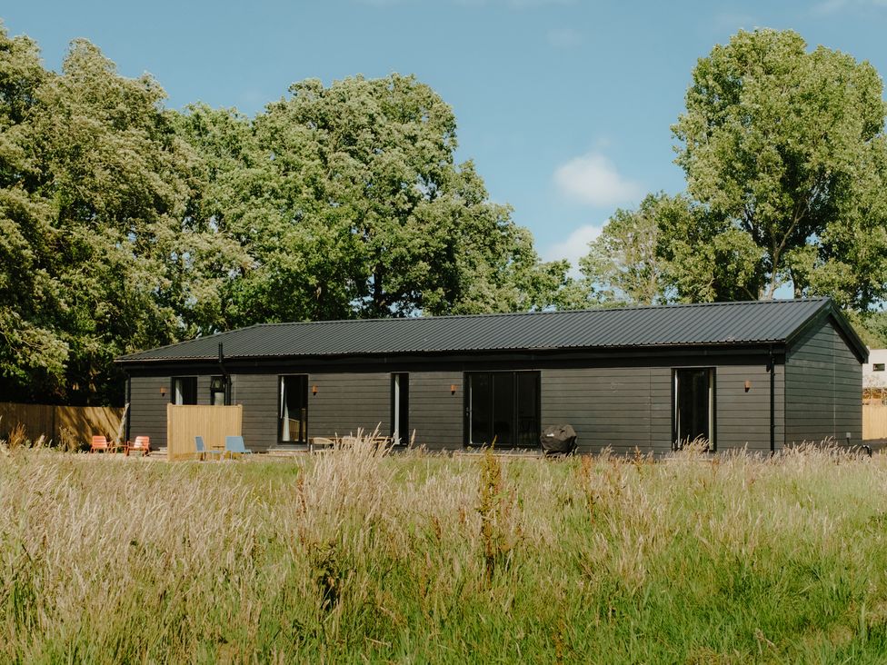 A house surrounded by grass and trees at Baldslow Barn in Battle near Hastings