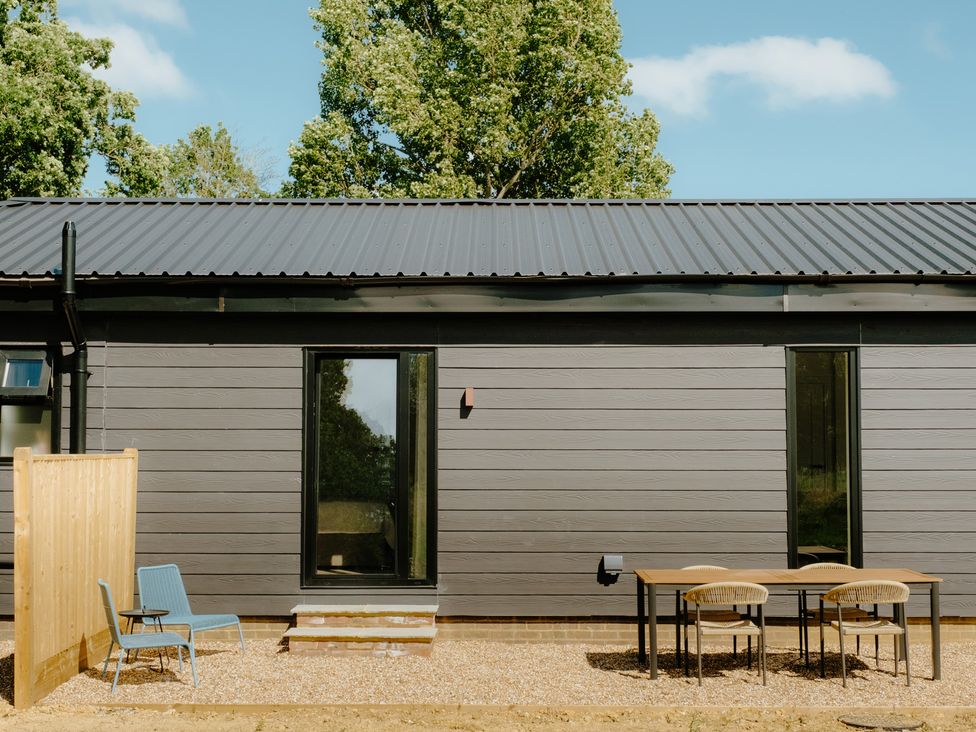 An outdoor area with a table and chairs at Baldslow Barn near Hastings