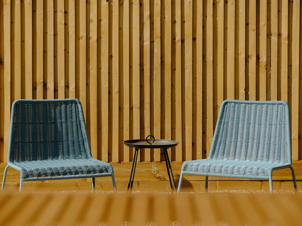 An outdoor lounge area with two chairs and a small table at Baldslow Barn near Hastings