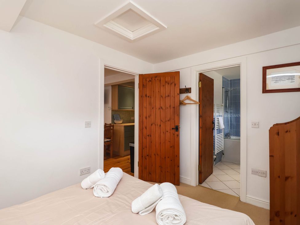 A bedroom with a bed and towels visible at Iris at Stancombe Manor Sherford near Chillington