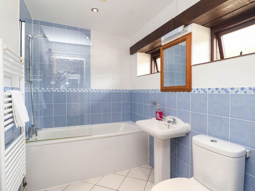 A bathroom with a bathtub, sink, toilet and shower at Iris at Stancombe Manor in Sherford near Chillington