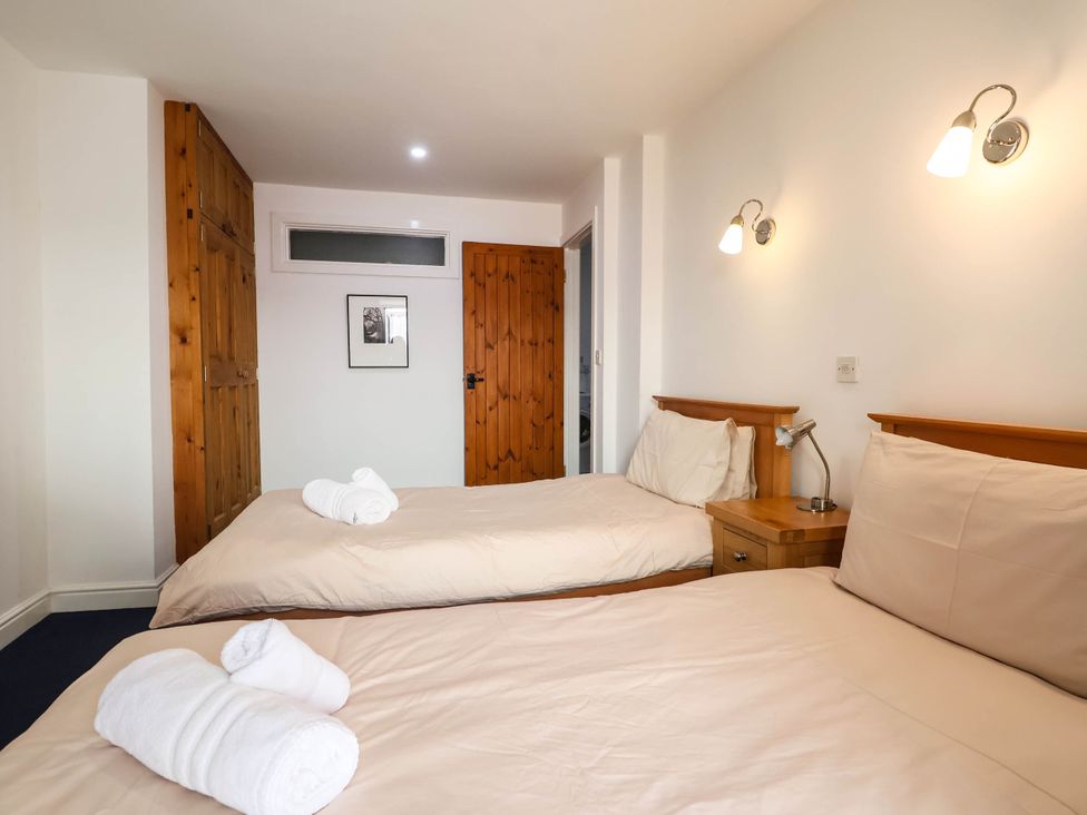 A bedroom with two single beds and wooden furniture at Iris at Stancombe Manor Sherford near Chillington