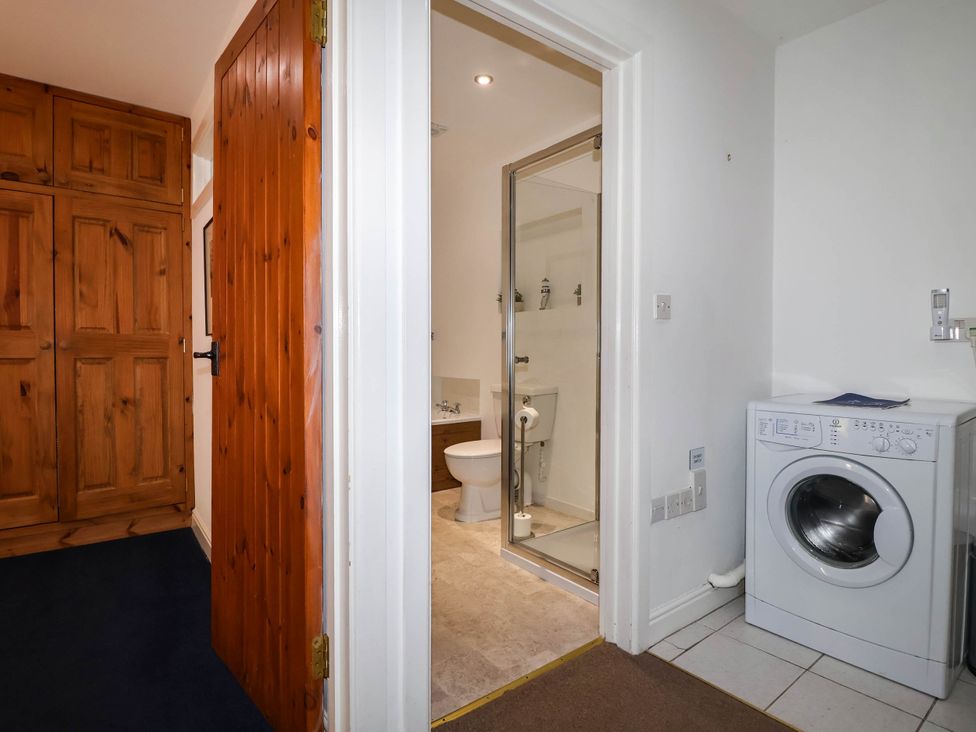 A bathroom with a shower and washing machine at Iris at Stancombe Manor Sherford near Chillington
