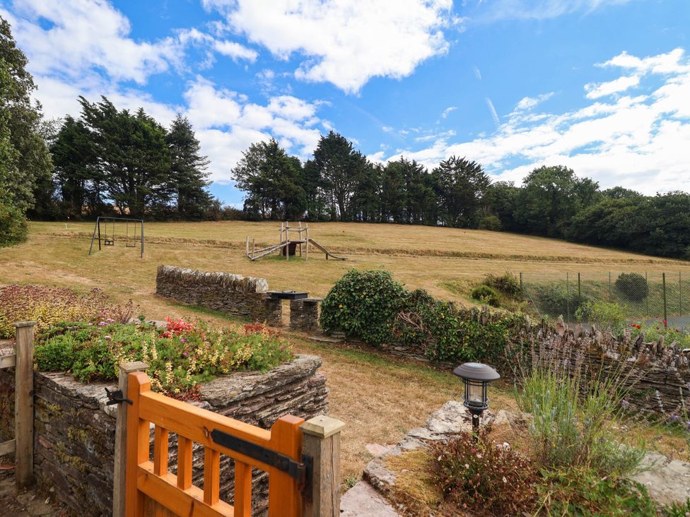 An outdoor area with a swing set and pathway at Iris at Stancombe Manor Sherford near Chillington