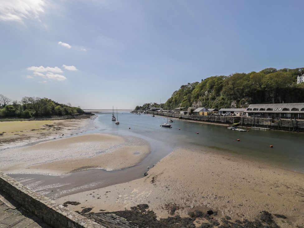 A river with boats and buildings alongside at Seafarer's Haven in Porthmadog