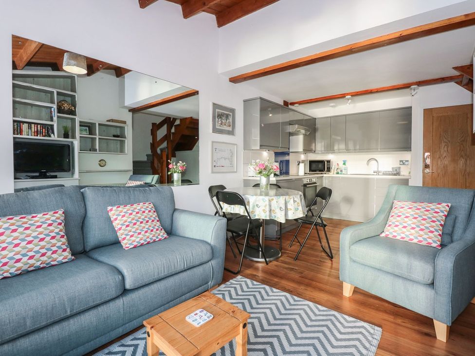 A living room with a sofa and dining area at Seafarer's Haven in Porthmadog
