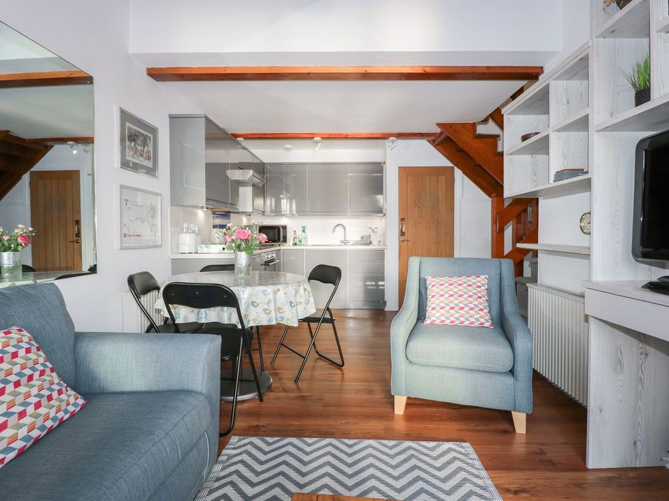 A living room with a sofa and dining area at Seafarer's Haven in Porthmadog