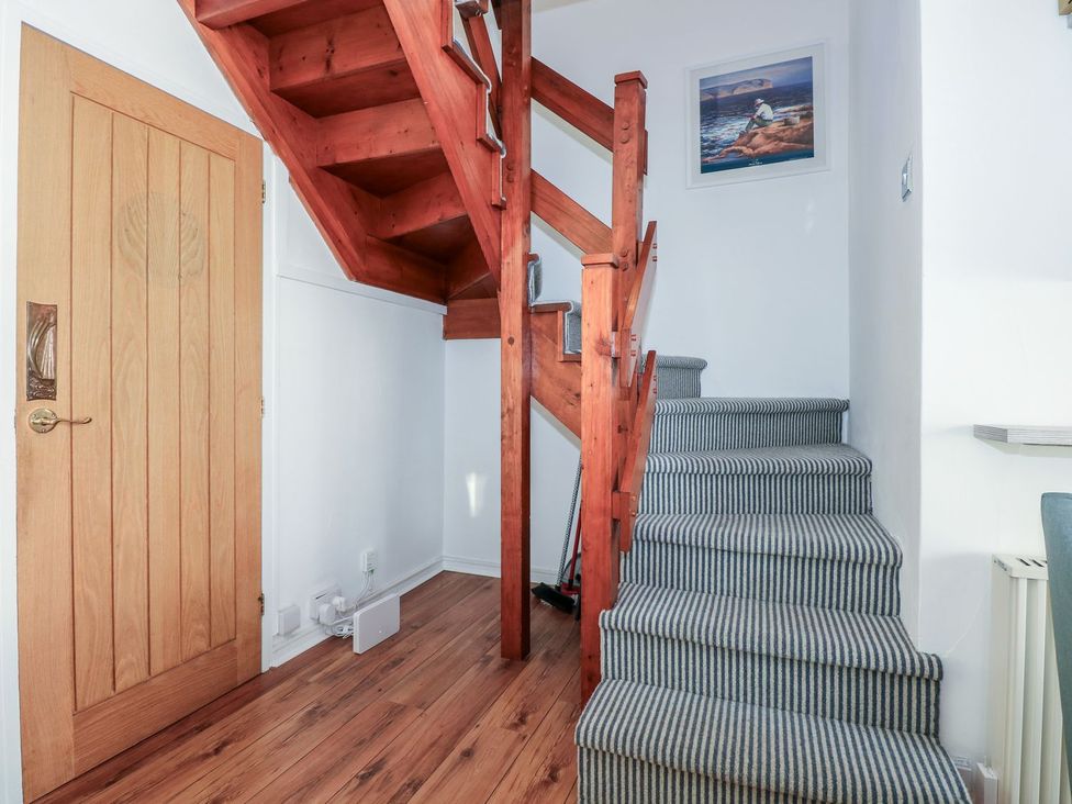 A staircase with wooden steps and a door at Seafarer's Haven in Porthmadog