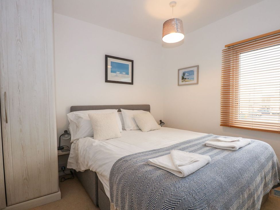 A bedroom with a bed and wardrobe at Seafarer's Haven in Porthmadog