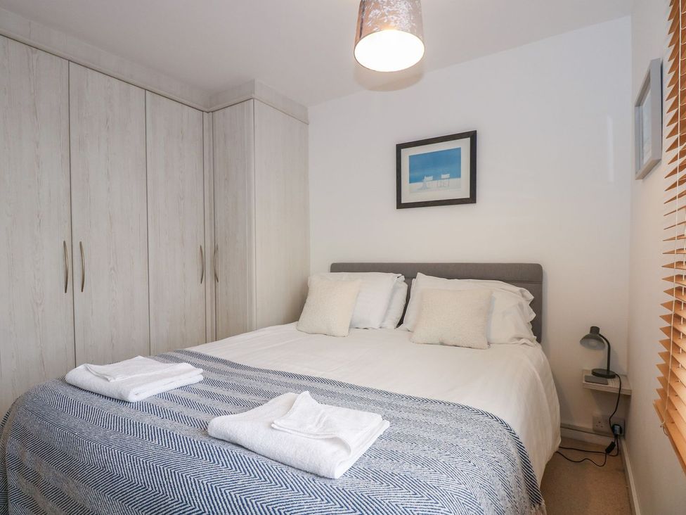 A bedroom with a bed and wardrobe at Seafarer's Haven in Porthmadog