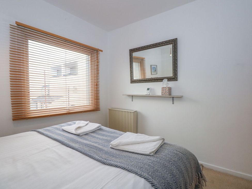 A bedroom with a bed and window at Seafarer's Haven in Porthmadog