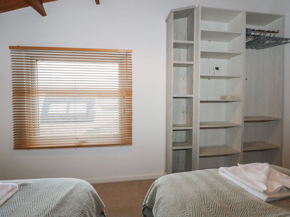 A bedroom with a window and shelving units at Seafarer's Haven in Porthmadog