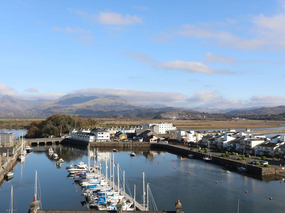 A harbor with boats in water and houses near the shore at Seafarer's Haven in Porthmadog