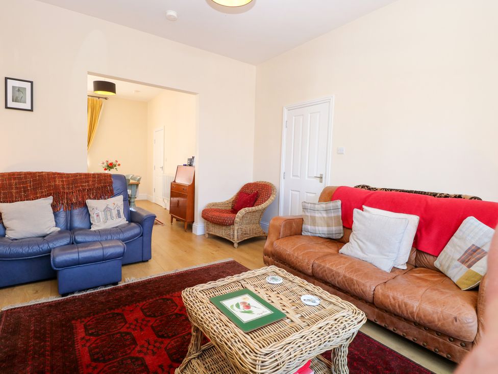 A living room with a sofa and armchairs at 33 North Denes in Great Yarmouth