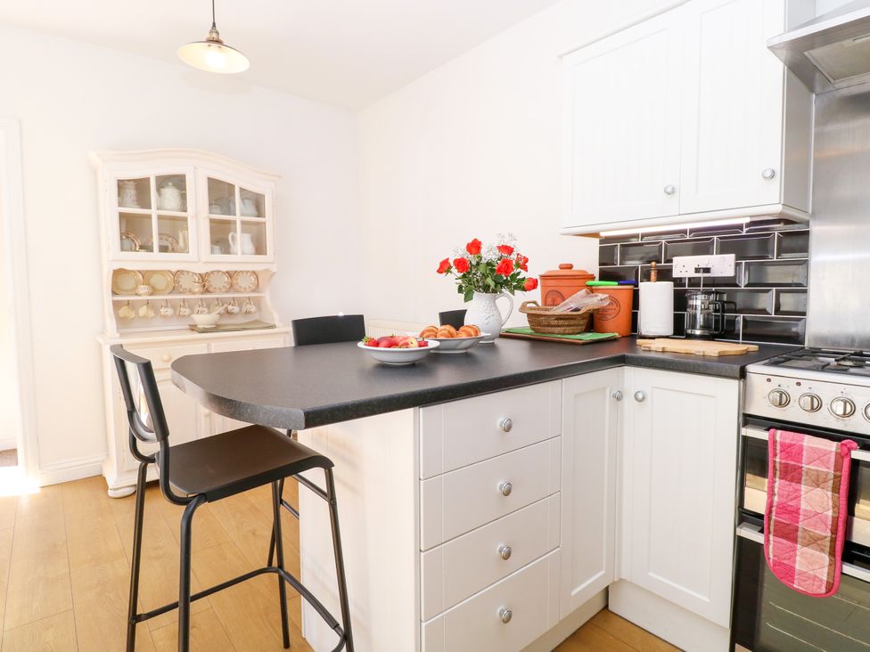 A kitchen with countertop, chairs and flowers at 33 North Denes in Great Yarmouth