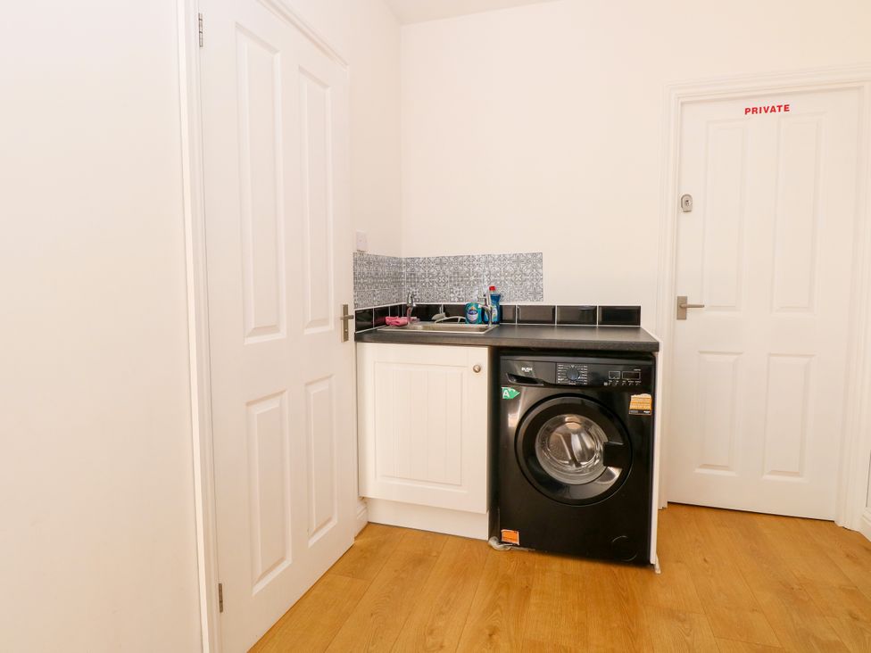 A laundry room with a washing machine and a sink at 33 North Denes Great Yarmouth
