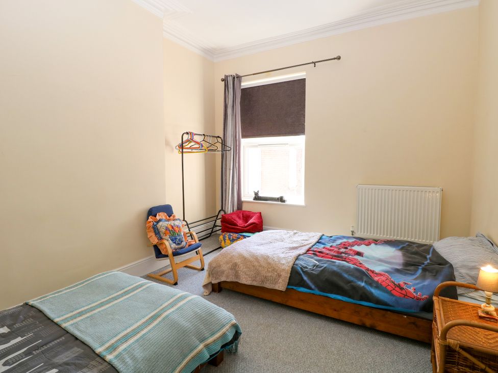 A bedroom with two beds and a clothes rack at 33 North Denes in Great Yarmouth