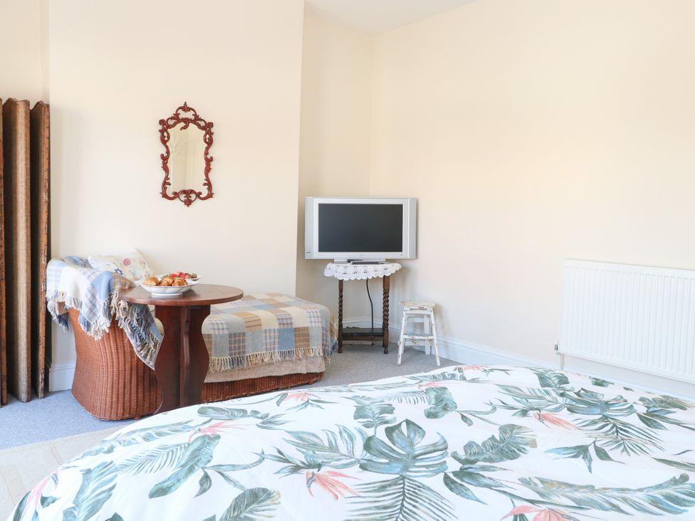 A bedroom with a bed, table, and TV at 33 North Denes in Great Yarmouth