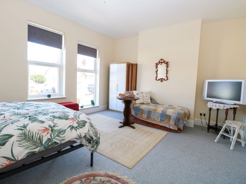 A bedroom with a bed, sofa, and television at 33 North Denes in Great Yarmouth