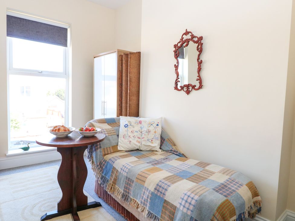 A sitting room with a sofa, table, and mirror at 33 North Denes in Great Yarmouth