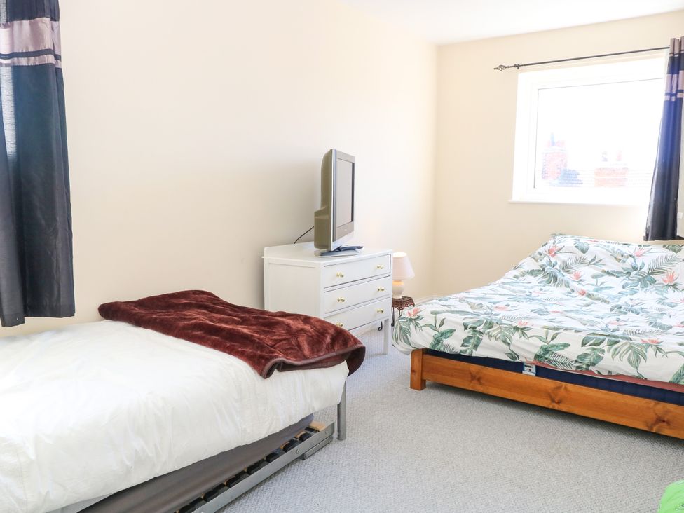 A bedroom with two beds and a television at 33 North Denes in Great Yarmouth