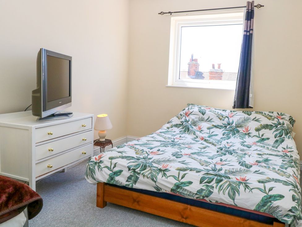 A bedroom with a bed, television and dresser at 33 North Denes in Great Yarmouth