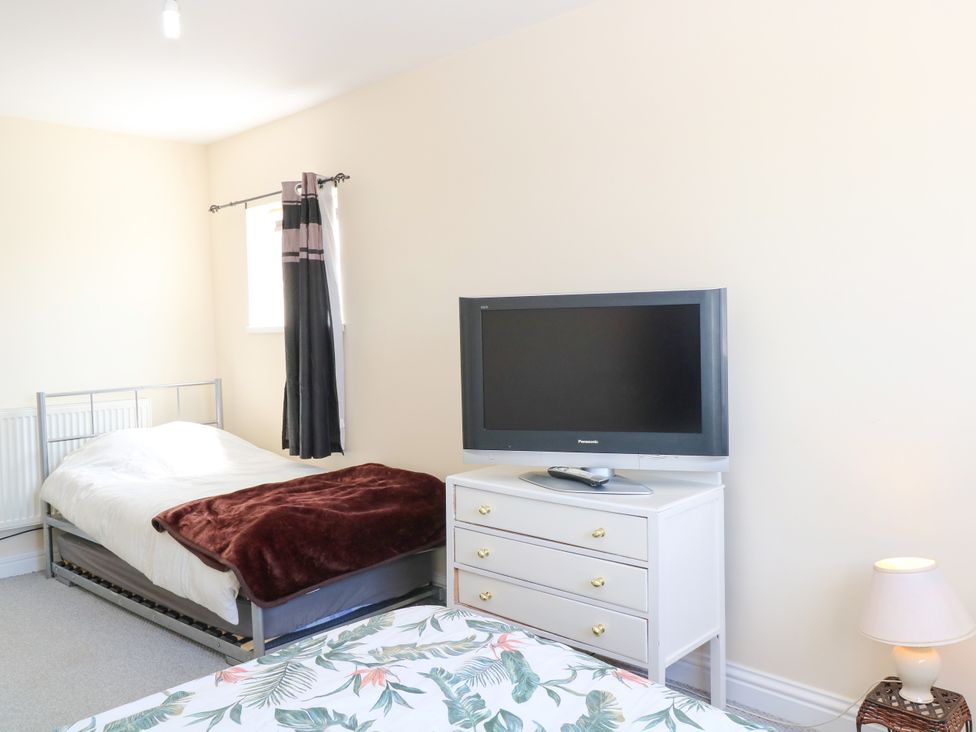 A bedroom with two beds and a television at 33 North Denes in Great Yarmouth