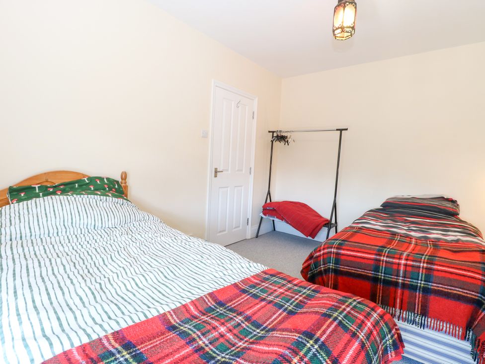A bedroom with two beds and a clothes rack at 33 North Denes Great Yarmouth