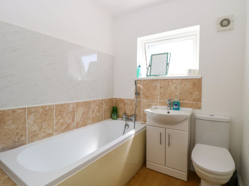 A bathroom with a bathtub, sink and toilet at 33 North Denes in Great Yarmouth