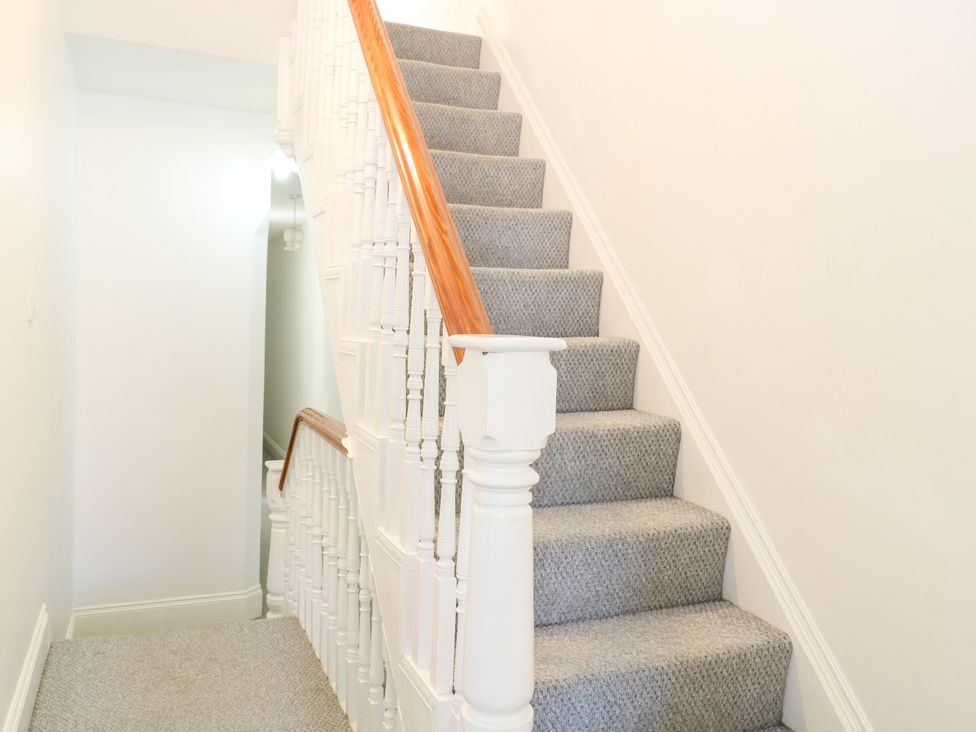 A staircase with carpet and a banister at 33 North Denes Great Yarmouth