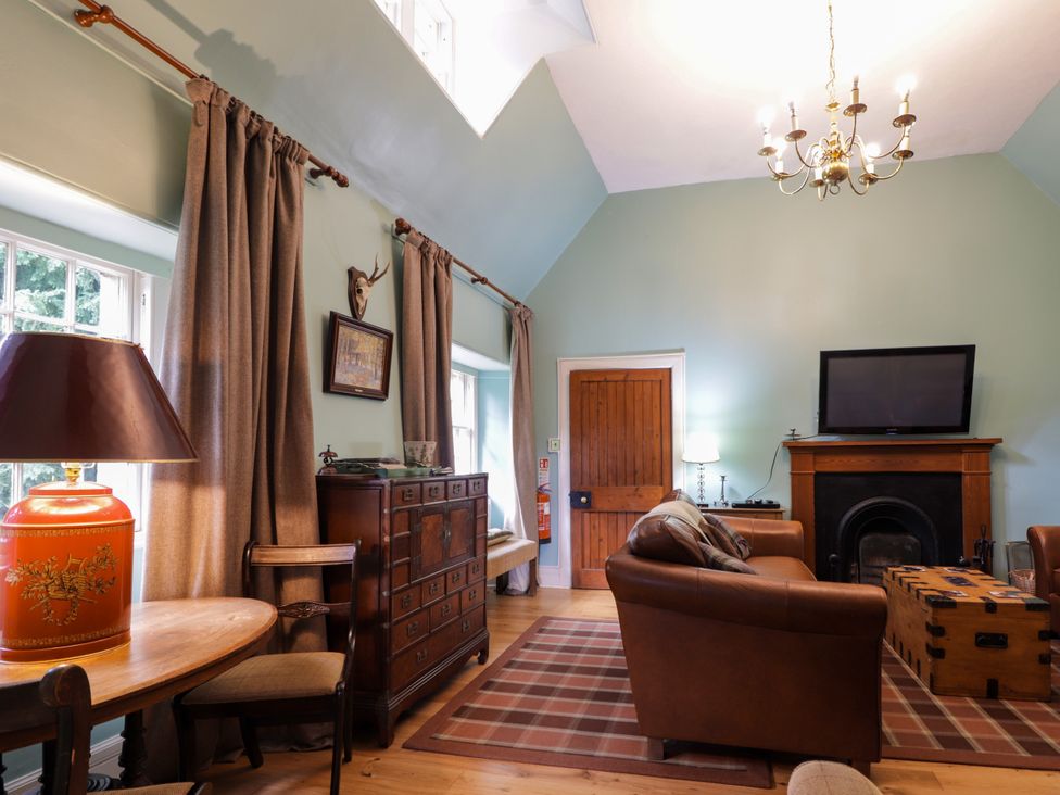 A living room with a sofa and a television at Tressady Coach House in Rogart