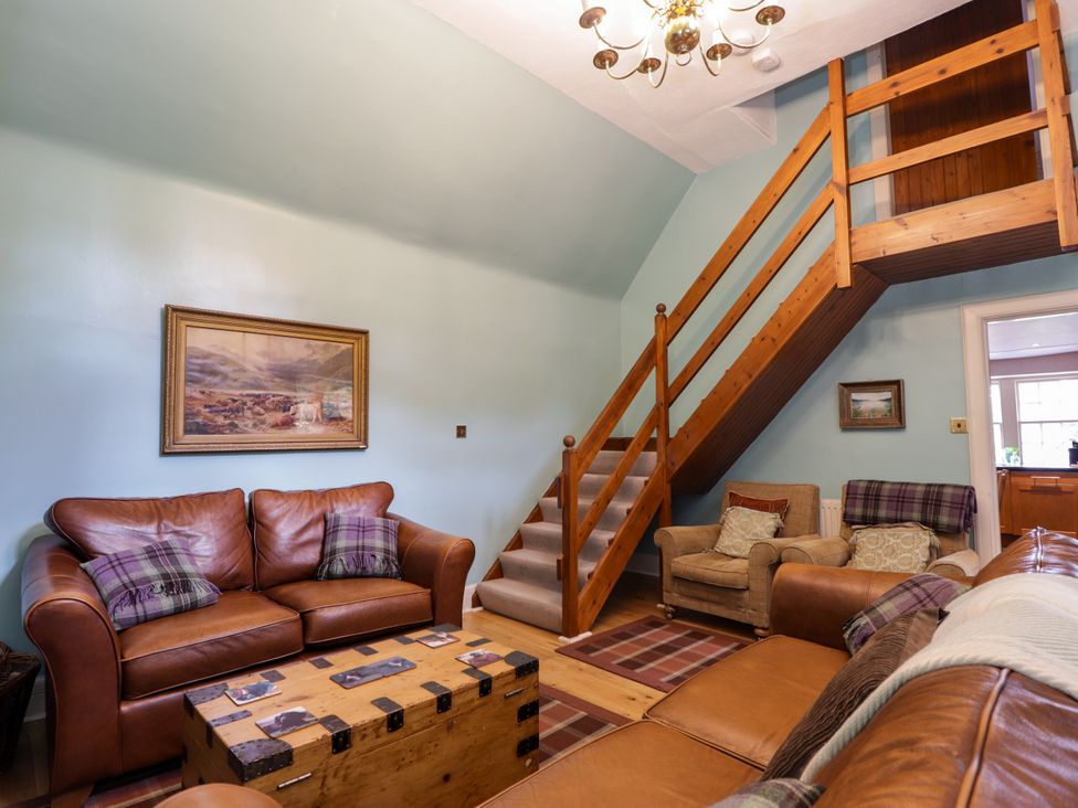 A living room with a sofa and coffee table at Tressady Coach House in Rogart