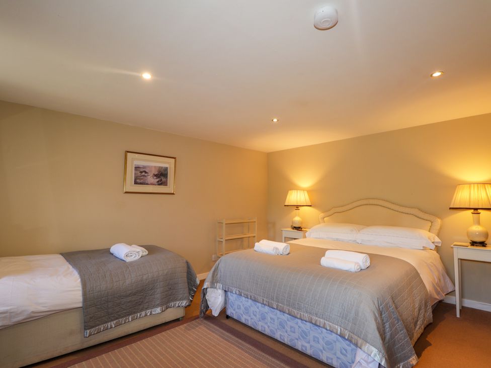 A bedroom with two beds and lamps at Tressady Coach House in Rogart
