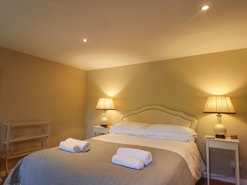 A bedroom with a bed and lamps at Tressady Coach House in Rogart