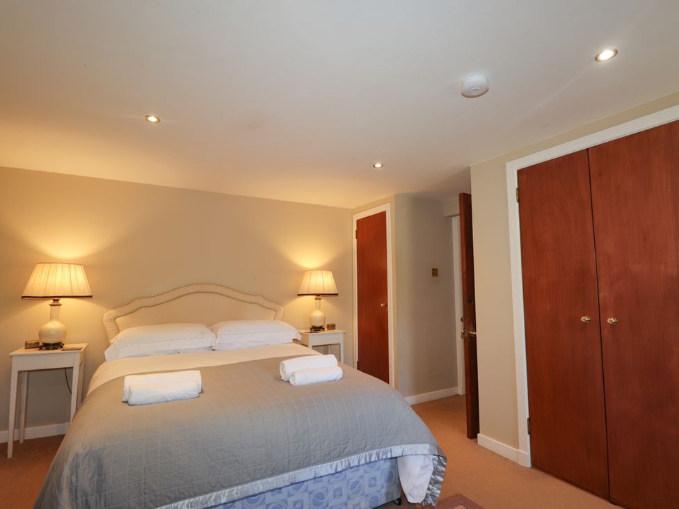 A bedroom with a bed and lamps at Tressady Coach House in Rogart