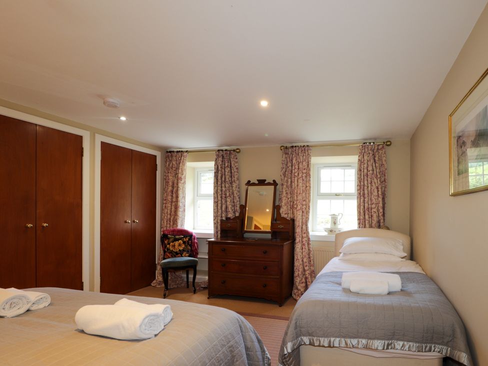 A bedroom with two beds and a dresser at Tressady Coach House in Rogart