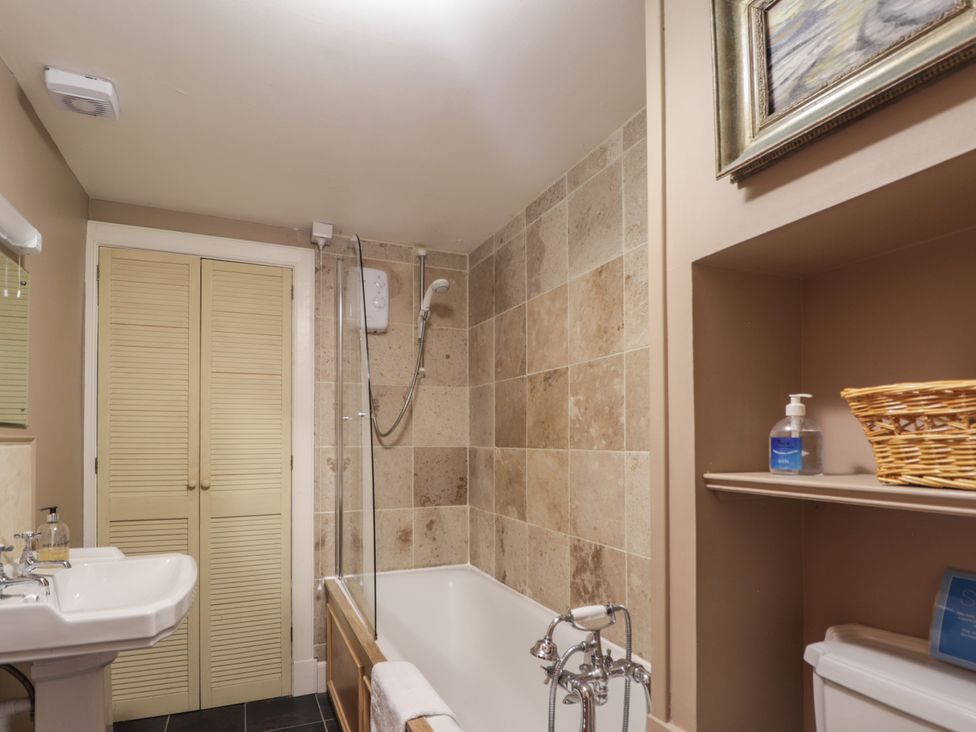 A bathroom with a bathtub, sink, and shower at Tressady Coach House in Rogart