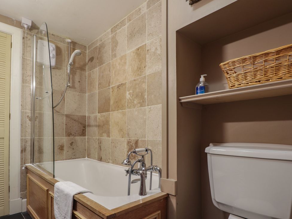 A bathroom with a bathtub and shower at Tressady Coach House in Rogart