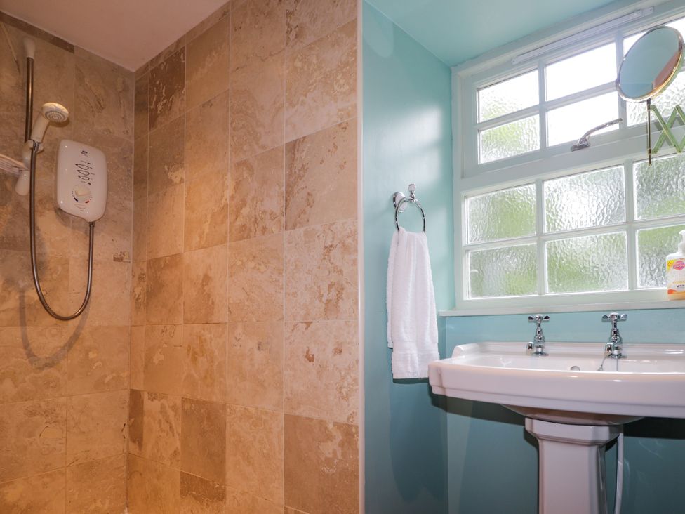 A bathroom with a shower and sink at Tressady Coach House in Rogart