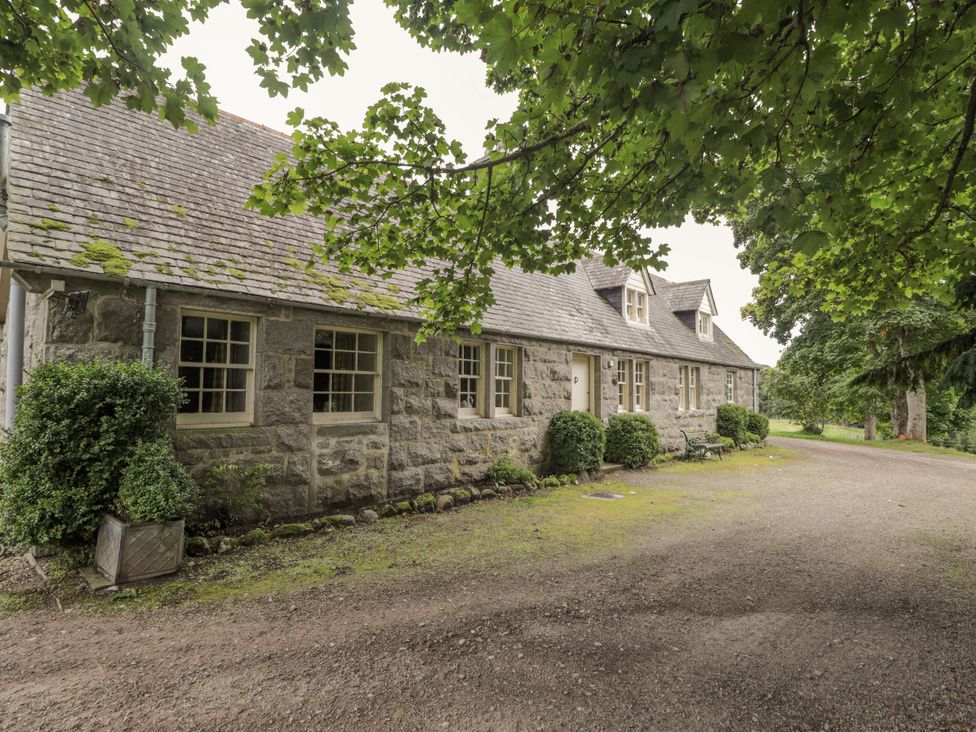 A house surrounded by trees and bushes at Tressady Coach House in Rogart
