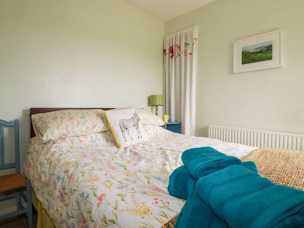 A bedroom with a bed and chair at The Granary 
