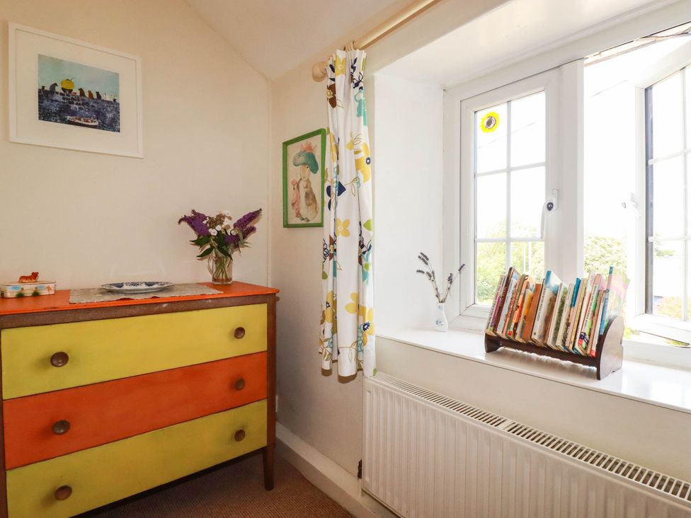 A corner with a dresser, vase, and bookshelf at The Granary in 