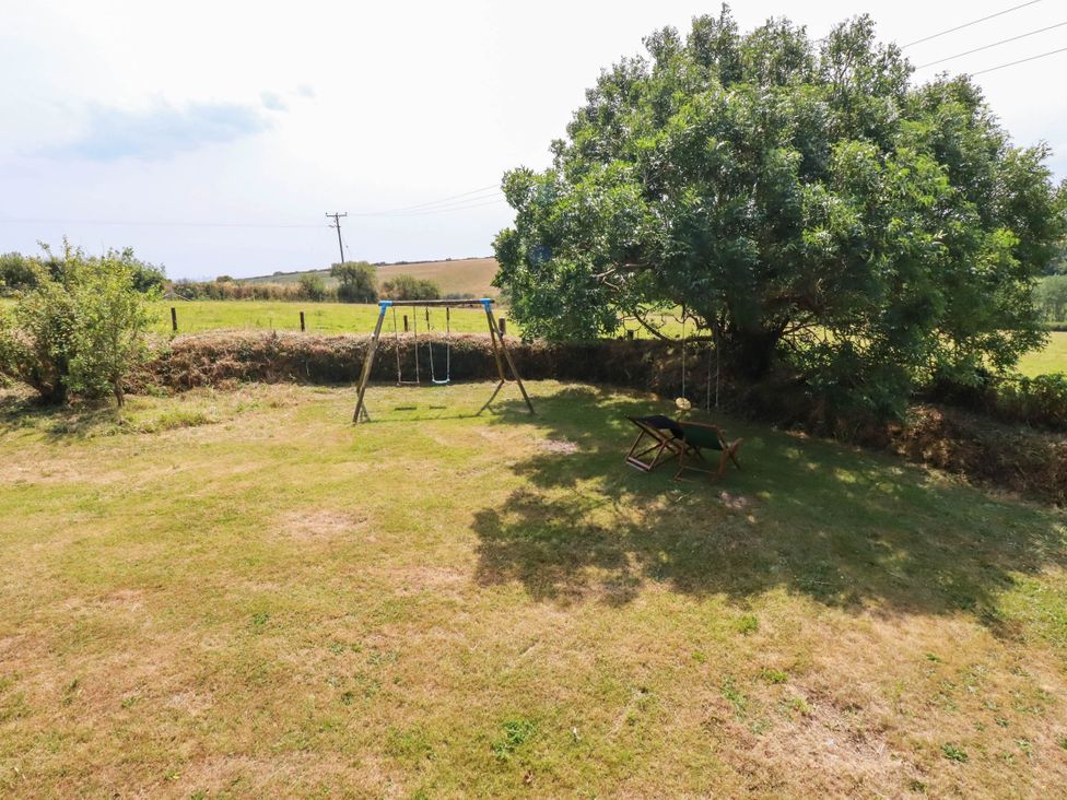 An outdoor area with a swing set and a tree at The Granary
