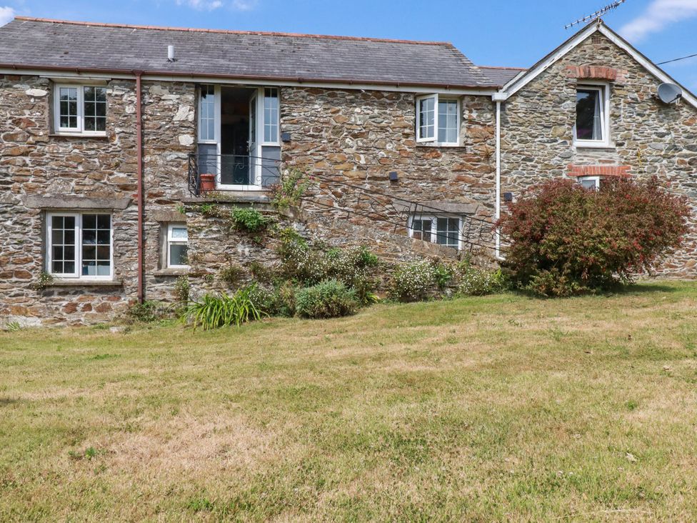 An outdoor view of a stone house with grass and shrubs at The Granary in 