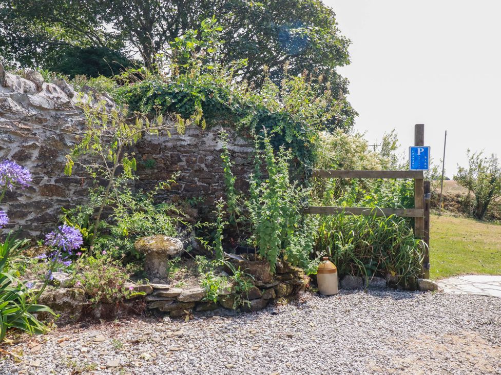 An outdoor area with a stone wall and plants at The Granary in 