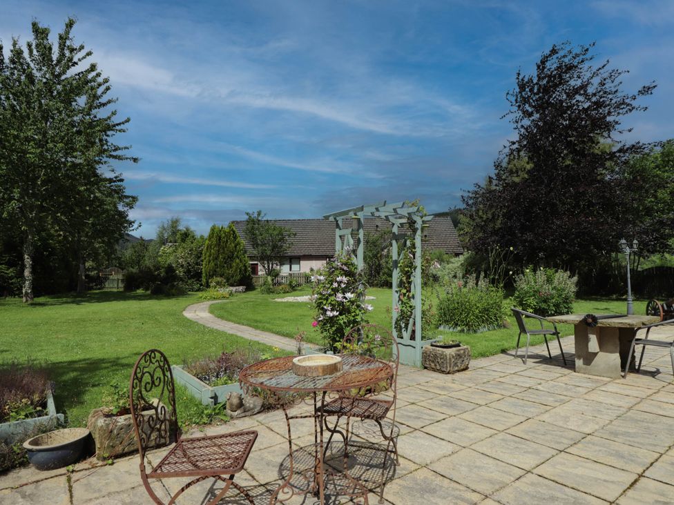 A garden with a table and chairs at Park House Cannich Holiday Retreat, Cannich